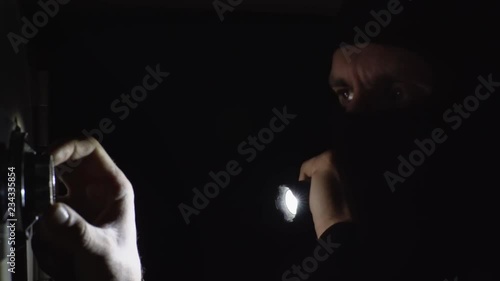 the thief is trying to open the safe in the night