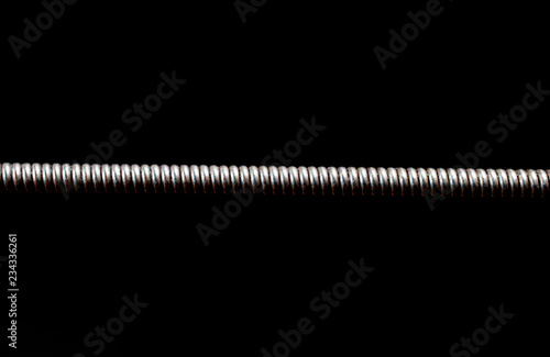 Extreme macro shot of a guitar string isolated on black (shallow DOF, selective focus)