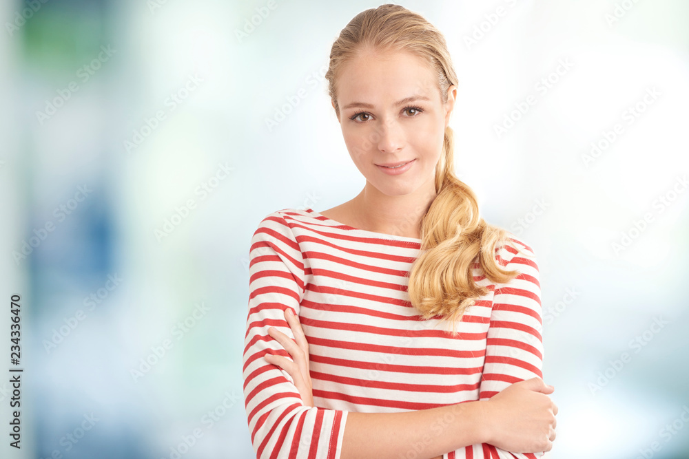Young beauty female portrait. Attractive young blond woman wearing striped shirt while looking at camera and smiling.