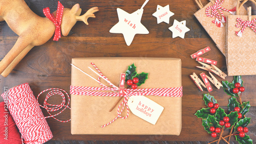 Christmas gift wrapping overhead in rustic theme with brown Kraft paper, string and natural ornaments, with applied filters. photo