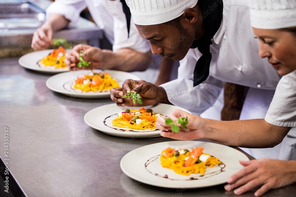 Chef garnishing food on plates Chef garnishing food on plates