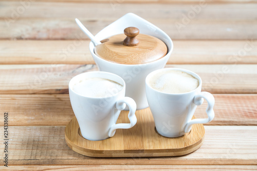 Photography coffee creamers. two cups of coffee on a wooden table.