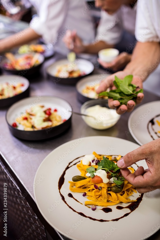 Chef garnishing food on plates Chef garnishing food on plates