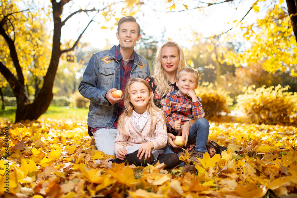 Photo of happy family with son and daughter on walk in autumn park Photo of happy family with son and daughter on walk in autumn park