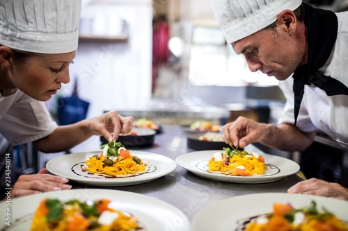 Chef garnishing food on plates