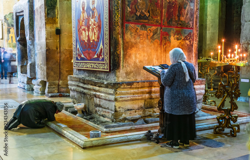 Woman praying in Svetitskhoveli Cathedral in Mtskheta, Georgia photo