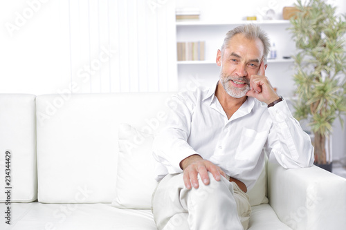 cheerful senior businessman sitting on the couch in the office