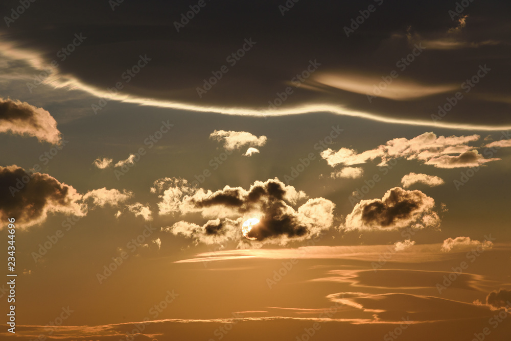 dramatic morning sky streaked with beautiful clouds, warm colors, abstract background