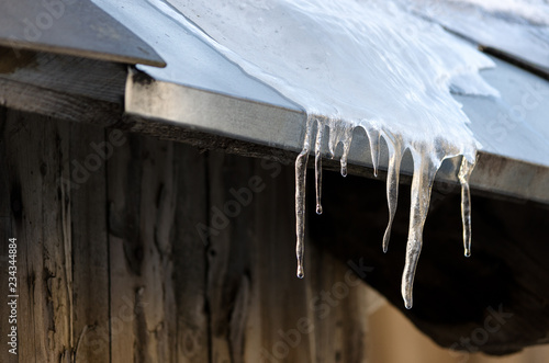 Ice stalactites hanging from the roof, beautiful winter detail, cold weather  © Linda