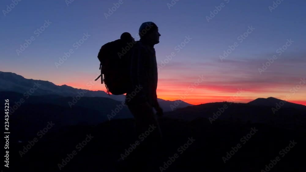 silhouette of tourist hiker man with backpack at sunset. traveler man climbing up in mountains reaching top standing with raised hands on top mountain enjoying nature. travel tourism happy holiday sky silhouette of tourist hiker man with backpack at sunset. traveler man climbing up in mountains reaching top standing with raised hands on top mountain enjoying nature. travel tourism happy holiday sky