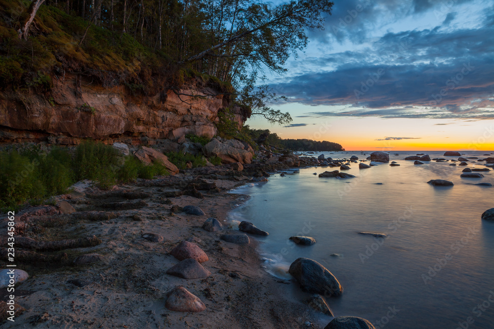 Late sunset over the limestone cliff along the sea. Estonia. Late sunset over the limestone cliff along the sea. Estonia.