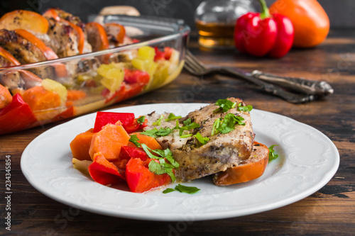 Spicy pork fillet baked with persimmon, apple, onion, carrot, bell pepper and celery on white table on wooden rustic table