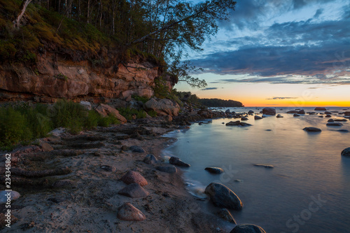 Late sunset over the limestone cliff along the sea. Estonia.