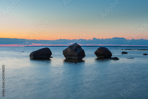Rocky coast of the sea with the boulders. Night time after sunset.