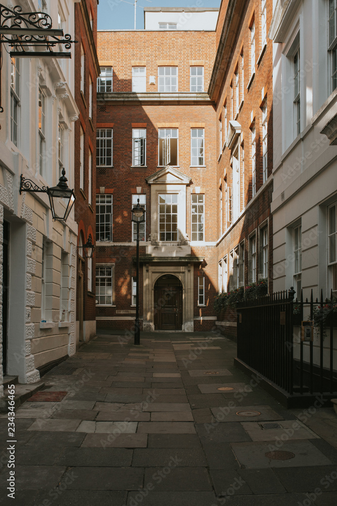 Classic english architecture in an interior court with building door entrances and windows, with daylight, in London city center, United Kingdom.