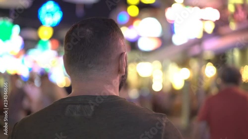 Happy man walking at night on the streets and admires it 