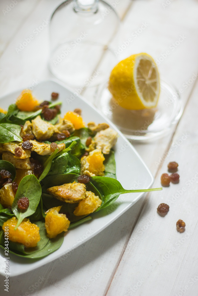 healthy salad with oranges, basil, raisins and honey dressing on white rustic background healthy salad with oranges, basil, raisins and honey dressing on white rustic background