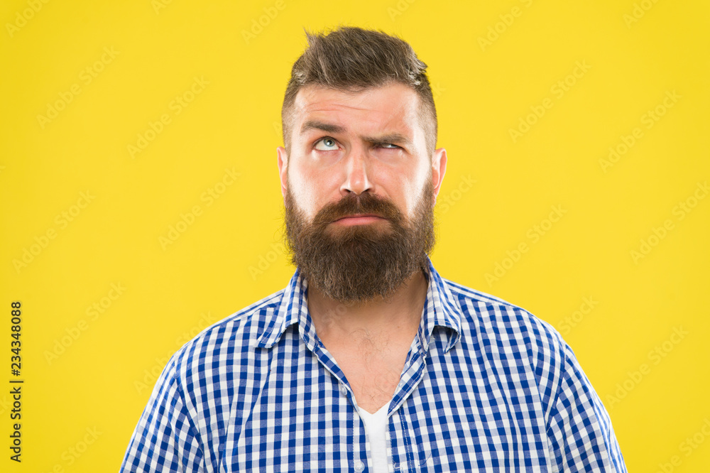 Fototapeta premium Need to think. Man serious face raising eyebrow not confident. Have some doubts. Hipster bearded face not sure in something. Doubtful bearded man on yellow background close up. Doubtful expression