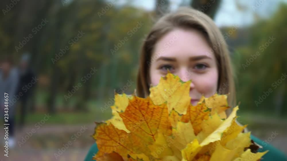 Autumn portrait of beautiful woman over yellow leaves while walking in the park in fall. The camera pans around the young woman. Girl is spinning. Blonde young girl in a green coat. Autumn portrait of beautiful woman over yellow leaves while walking in the park in fall. The camera pans around the young woman. Girl is spinning. Blonde young girl in a green coat.