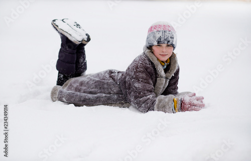 Cute little girl walking in snow park, happy childhood
