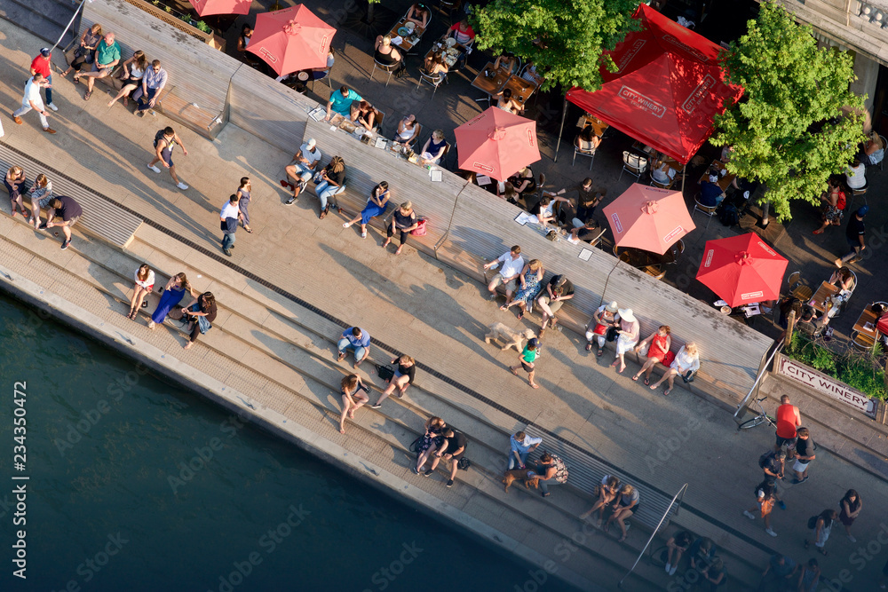 Obraz premium Widok z lotu ptaka ludzi siedzących i chodzących nad brzegiem rzeki w Chicago w słoneczny letni dzień