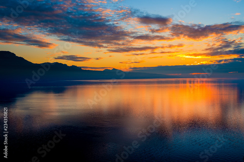 Beautiful colorful sunset in the autumn above the French Alps and Lake Geneva where the colors and clouds reflect beautifully.