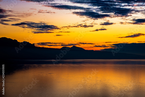 Beautiful colorful sunset in the autumn above the French Alps and  Lake Geneva where the colors and clouds reflect beautifully. © FotoCorn