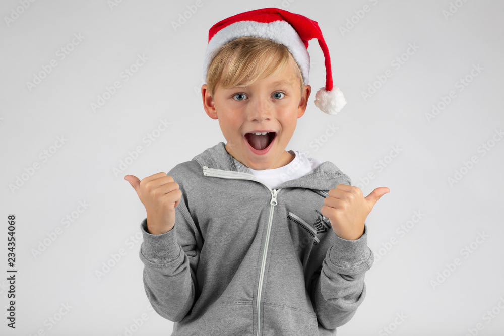 Little boy with a red Santa hat is happy and has thumbs up Little boy with a red Santa hat is happy and has thumbs up