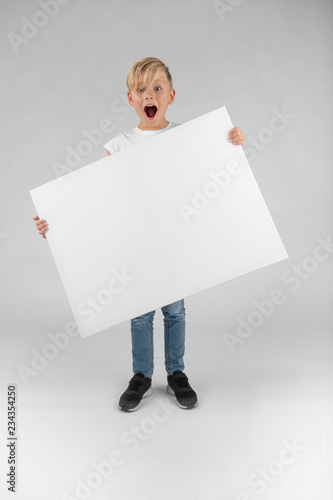 little blond boy holds a blank sign in his hands and open mouth