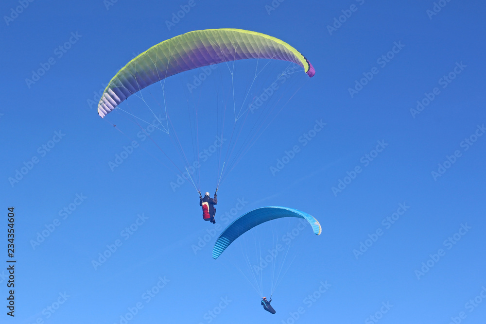 Paragliders flying in a blue sky Paragliders flying in a blue sky