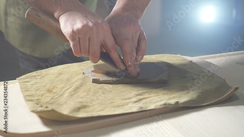 Sharpening carpenter's hand tool for working on wood close up, men's hands
