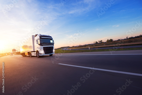 Loaded European truck on motorway in sunset photo