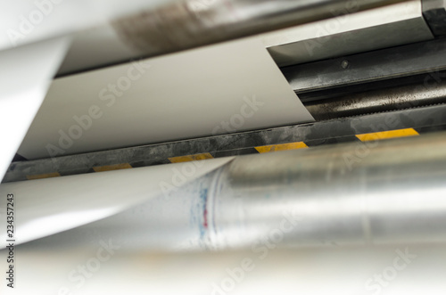 Closeup of printng machine working with roll paper for magazine production photo