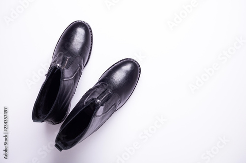 Woman accessory. Black stylish boots on white background. Top view background. Flat lay. Copy space.