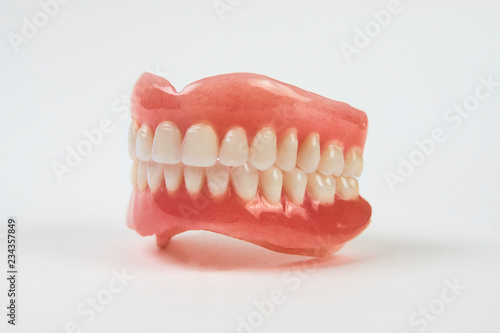 Artificial teeth on a white background with copy space.
