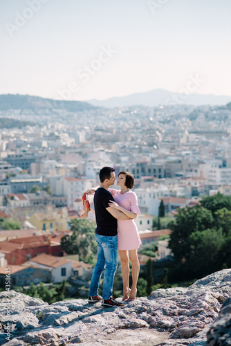 couple have a date on the peak of the hill with panorama view on the city kissing each other