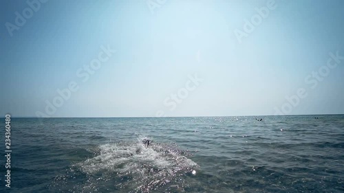 Sport athlete fit male running to the sea water and jump into