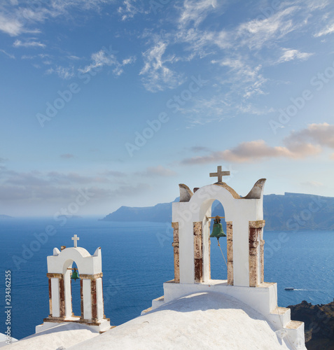 white church belfries against volcano caldera with blue sea, beautiful details of Santorini island, Greece