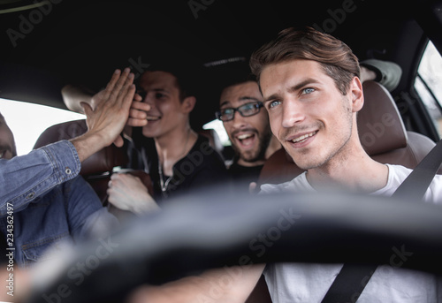 A group of people inside a car, on a road trip