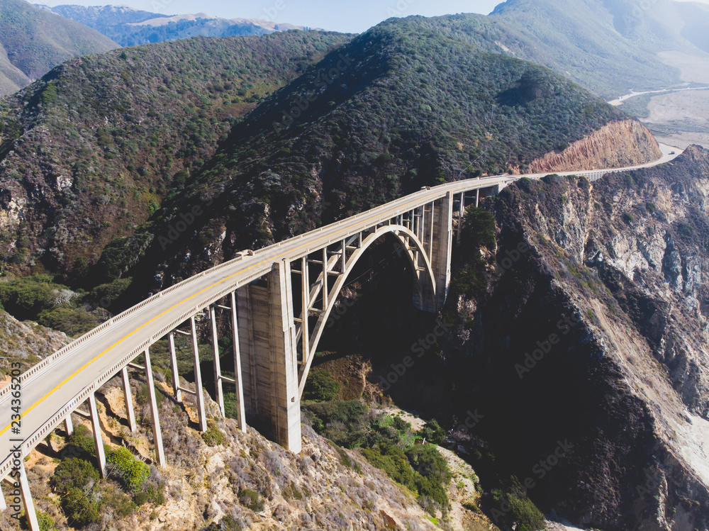 Aerial panoramic view of historic Bixby Creek Bridge along world famous Pacific Coast Highway 1 in summer sunny day , Monterey County, California, USA, shot from drone Aerial panoramic view of historic Bixby Creek Bridge along world famous Pacific Coast Highway 1 in summer sunny day , Monterey County, California, USA, shot from drone
