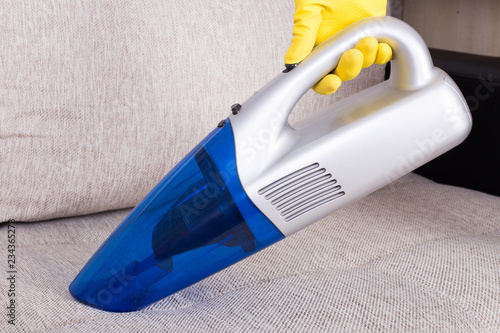 Hoovering sofa with vacuum cleaner photo