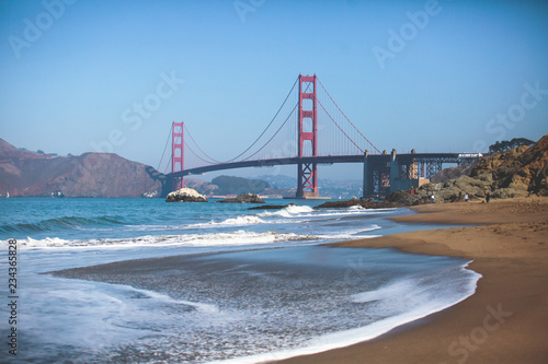 Classic panoramic view of famous Golden Gate Bridge seen from Baker Beach in beautiful summer sunny day with blue sky, San Francisco, California, USA