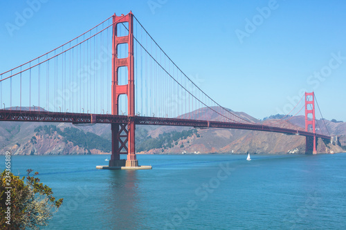 Classic panoramic view of famous Golden Gate Bridge seen from Baker Beach in beautiful summer sunny day with blue sky, San Francisco, California, USA © tsuguliev