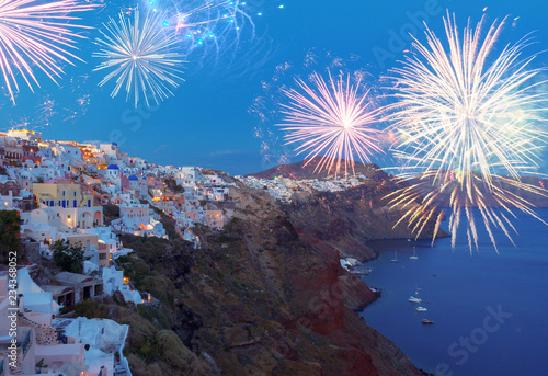 cityscape of Oia village at night with fireworks, Santorini Greece.