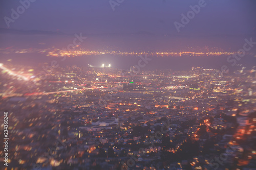 Beautiful super wide-angle night aerial view of San Francisco, California, with Downtown and Bay Bridge, and skyline scenery beyond the city, seen from Twin Peaks hills
