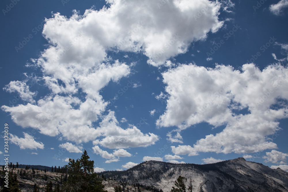 Puffy white clouds over a mountain range Puffy white clouds over a mountain range