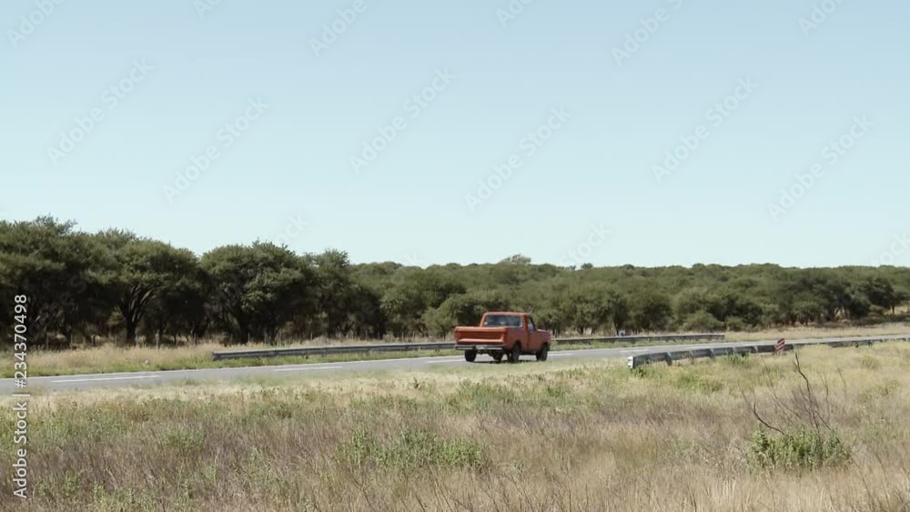 Red Pickup Truck Driving On Country Road / Argentina. Red Pickup Truck Driving On Country Road / Argentina.
