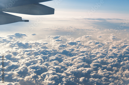 Travel background of plane flying above the clouds
