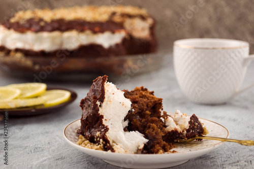 Interrupted dessert. The remains of the chocolate cake. White dishes for dessert. Light background.