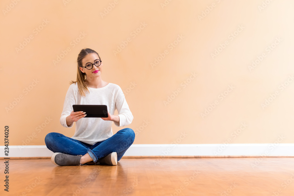 Young woman with a tablet computer against a big interior wall Young woman with a tablet computer against a big interior wall